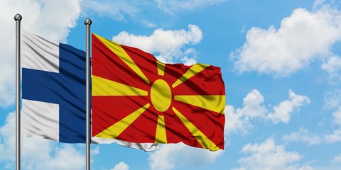 Finland and Macedonia flag waving in the wind against white cloudy blue sky together. Diplomacy concept, international relations.