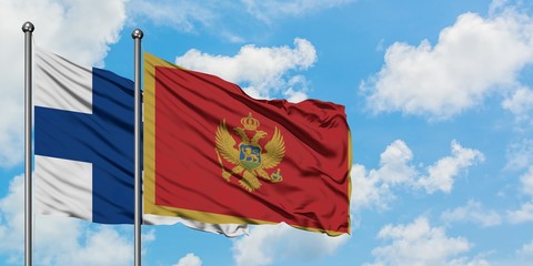 Finland and Montenegro flag waving in the wind against white cloudy blue sky together. Diplomacy...
