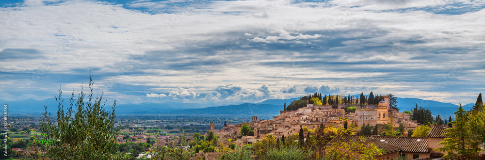 Wall mural Panoramic view of Spello medieval hisitoric center and Umbria countryside with beautiful clouds above