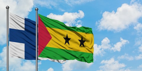 Finland and Sao Tome And Principe flag waving in the wind against white cloudy blue sky together....