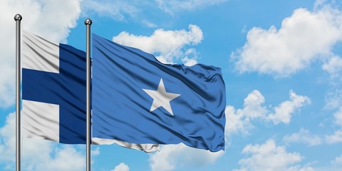 Finland and Somalia flag waving in the wind against white cloudy blue sky together. Diplomacy...