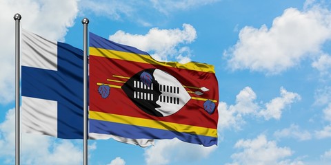 Finland and Swaziland flag waving in the wind against white cloudy blue sky together. Diplomacy...