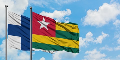 Finland and Togo flag waving in the wind against white cloudy blue sky together. Diplomacy concept, international relations.