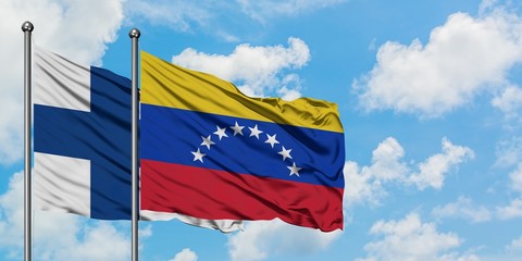 Finland and Venezuela flag waving in the wind against white cloudy blue sky together. Diplomacy concept, international relations.