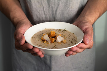 hands holding bowl of soup