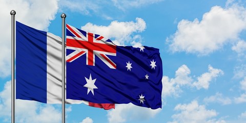 France and Australia flag waving in the wind against white cloudy blue sky together. Diplomacy concept, international relations.