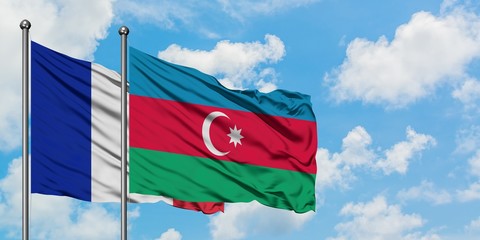 France and Azerbaijan flag waving in the wind against white cloudy blue sky together. Diplomacy...
