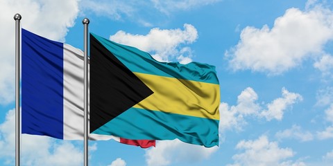 France and Bahamas flag waving in the wind against white cloudy blue sky together. Diplomacy concept, international relations.