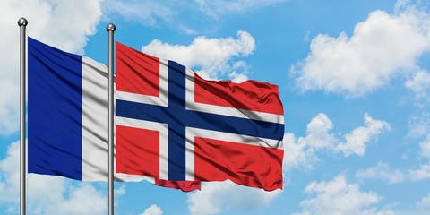 France and Bouvet Islands flag waving in the wind against white cloudy blue sky together. Diplomacy...