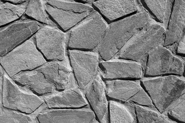 Wall made of old stones in black and white.