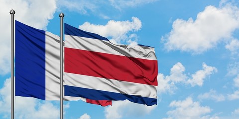 France and Costa Rica flag waving in the wind against white cloudy blue sky together. Diplomacy concept, international relations.