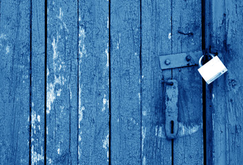 Grungy wooden door with lock in navy blue tone.
