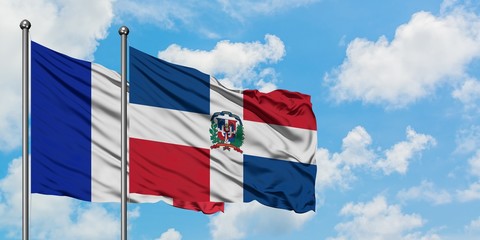 France and Dominican Republic flag waving in the wind against white cloudy blue sky together. Diplomacy concept, international relations.
