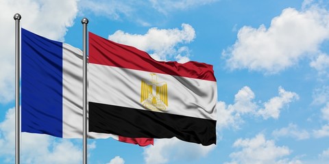 France and Egypt flag waving in the wind against white cloudy blue sky together. Diplomacy concept, international relations.