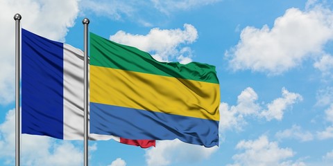 France and Gabon flag waving in the wind against white cloudy blue sky together. Diplomacy concept, international relations.