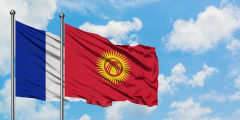 France and Kyrgyzstan flag waving in the wind against white cloudy blue sky together. Diplomacy concept, international relations.