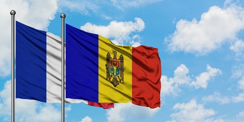 France and Moldova flag waving in the wind against white cloudy blue sky together. Diplomacy concept, international relations.