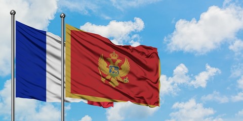 France and Montenegro flag waving in the wind against white cloudy blue sky together. Diplomacy...
