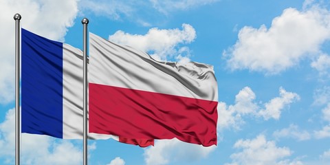 France and Poland flag waving in the wind against white cloudy blue sky together. Diplomacy concept, international relations.