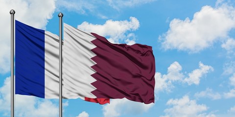 France and Qatar flag waving in the wind against white cloudy blue sky together. Diplomacy concept,...