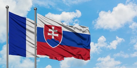 France and Slovakia flag waving in the wind against white cloudy blue sky together. Diplomacy...