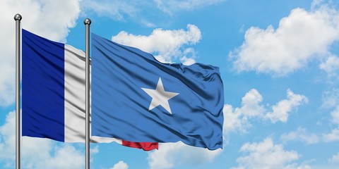 France and Somalia flag waving in the wind against white cloudy blue sky together. Diplomacy...