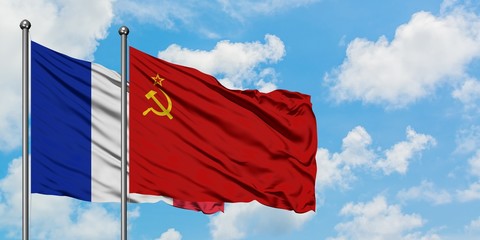 France and Soviet Union flag waving in the wind against white cloudy blue sky together. Diplomacy...