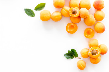 Fruit frame. Apricots and leaves on white background top view copy space