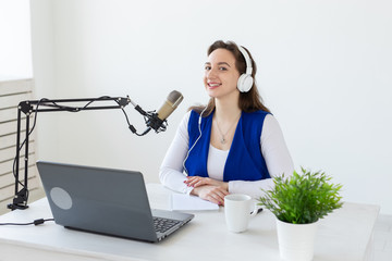 Radio, blogging, podcasting concept - young woman working as a dj on the radio.