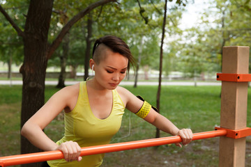 Young woman in sport wear at street workout area