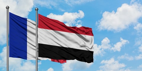 France and Yemen flag waving in the wind against white cloudy blue sky together. Diplomacy concept, international relations.