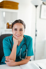 Young female doctor in medical office. Portrait of beautiful female doctor sitting in the clinic office.