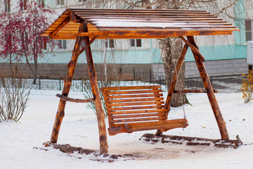 Beautiful wooden swing in winter in the Park