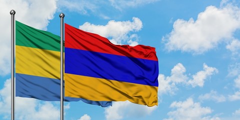 Gabon and Armenia flag waving in the wind against white cloudy blue sky together. Diplomacy concept, international relations.