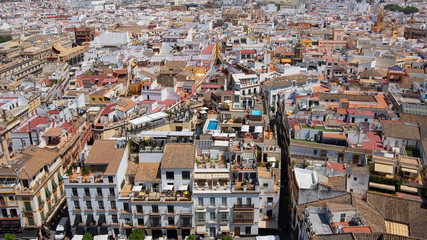 Fototapeta premium Panoramic aerial views of the city: buildings, streets, rooftops as seen from Giralda tower, part of the Seville Cathedral also known as Catedral de Santa María de la Sede de Sevilla, Andalusia, Spain