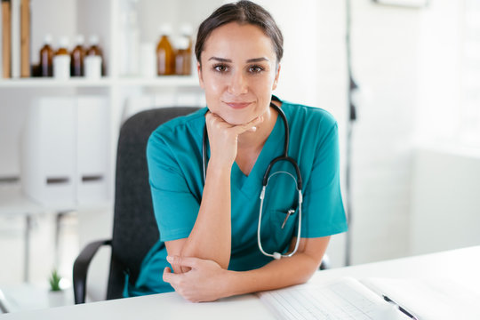 Young female doctor in medical office. Portrait of beautiful female doctor sitting in the clinic office.