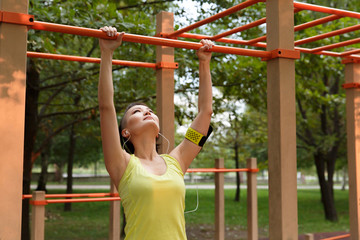 Young woman in sport wear at street workout area
