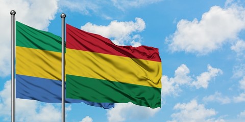 Gabon and Bolivia flag waving in the wind against white cloudy blue sky together. Diplomacy concept, international relations.