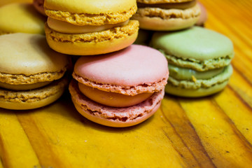 Colored macarons isolated on wooden dish, typical French dish
