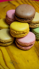 Colored macarons isolated on wooden dish, typical French dish