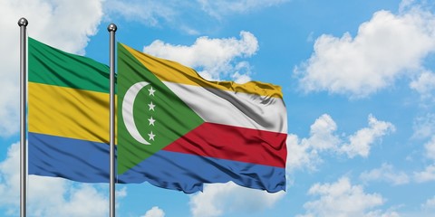 Gabon and Comoros flag waving in the wind against white cloudy blue sky together. Diplomacy concept, international relations.