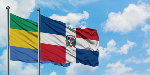 Gabon and Dominican Republic flag waving in the wind against white cloudy blue sky together. Diplomacy concept, international relations.
