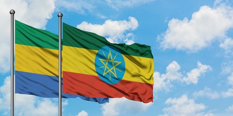 Gabon and Ethiopia flag waving in the wind against white cloudy blue sky together. Diplomacy...