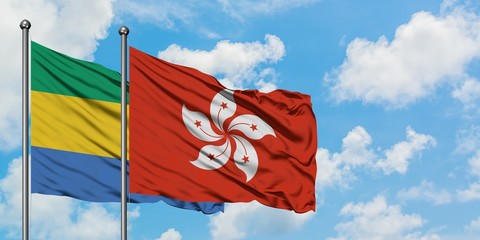 Gabon and Hong Kong flag waving in the wind against white cloudy blue sky together. Diplomacy concept, international relations.