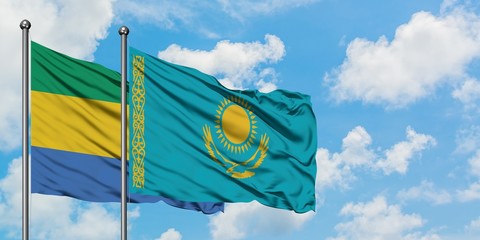 Gabon and Kazakhstan flag waving in the wind against white cloudy blue sky together. Diplomacy concept, international relations.