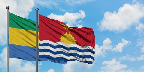 Gabon and Kiribati flag waving in the wind against white cloudy blue sky together. Diplomacy concept, international relations.