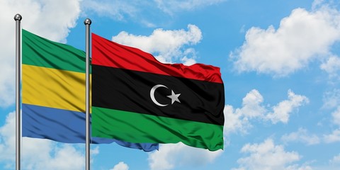 Gabon and Libya flag waving in the wind against white cloudy blue sky together. Diplomacy concept,...