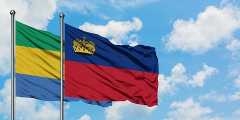 Gabon and Liechtenstein flag waving in the wind against white cloudy blue sky together. Diplomacy...