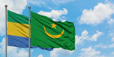 Gabon and Mauritania flag waving in the wind against white cloudy blue sky together. Diplomacy...