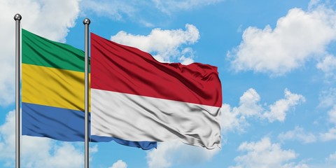 Gabon and Monaco flag waving in the wind against white cloudy blue sky together. Diplomacy concept,...